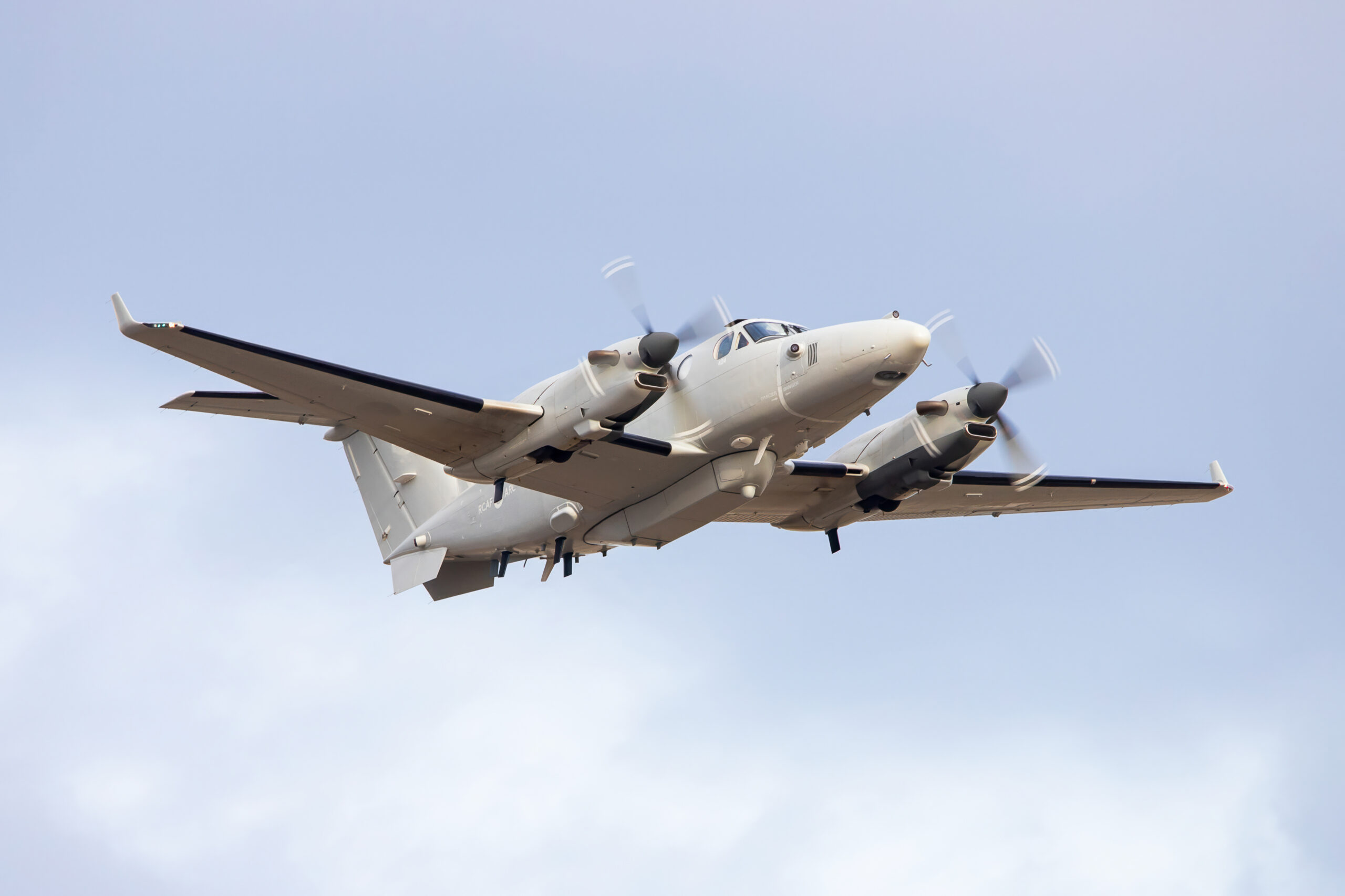 Gray propeller aircraft in a blue sky.